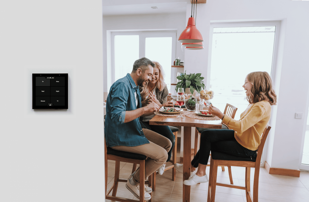 Family having lunch with Rithum SmartSwitch Lite showing scenes wall mounted in the foreground