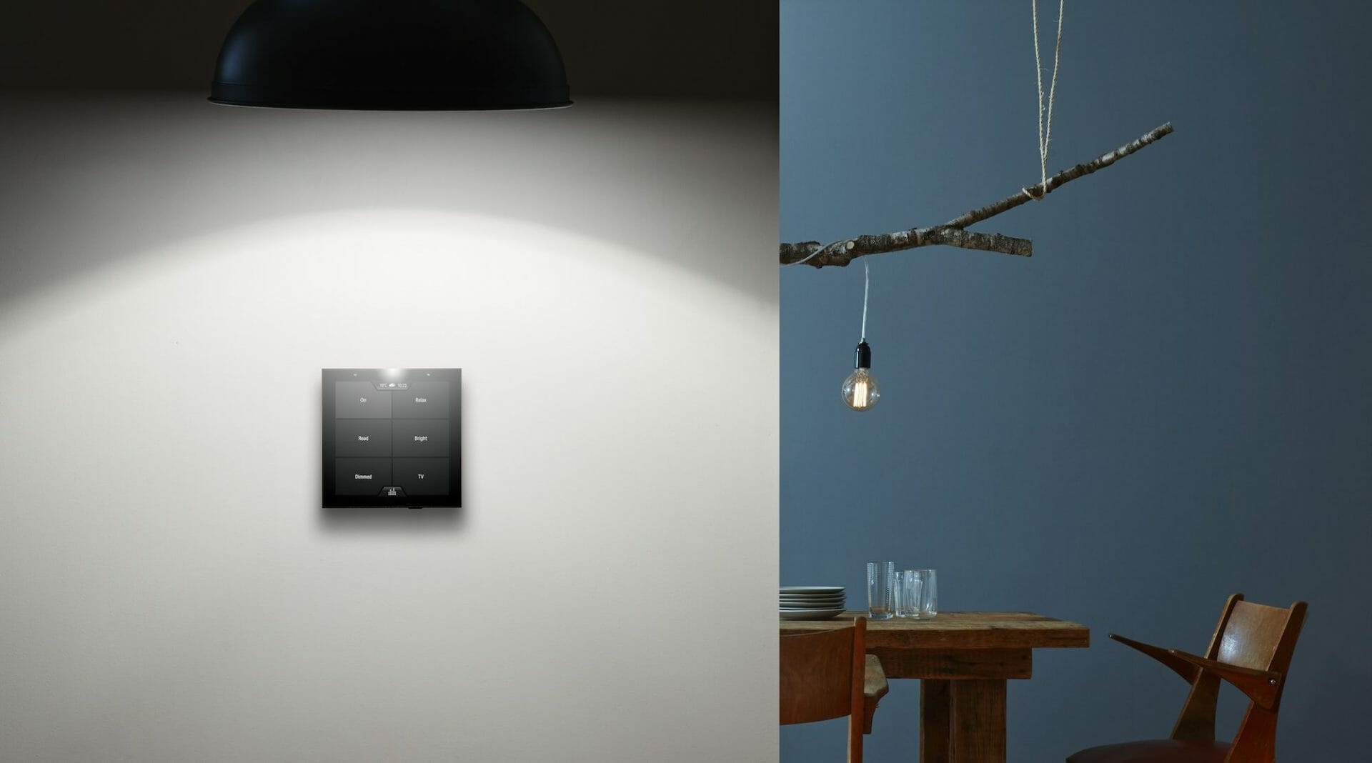 Violet's SmartSwitch Lite wall mounted with a lamp above it and a dining table in the background